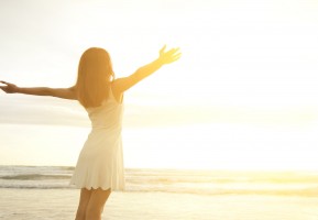 Smile Freedom and happiness woman on beach. She is enjoying serene ocean nature during travel holidays vacation outdoors. asian beauty