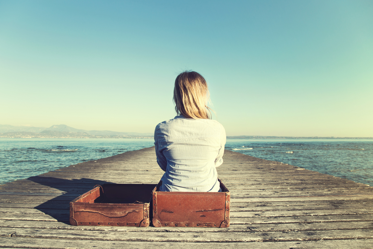 Picture of a woman thinking, sitting in a baggage